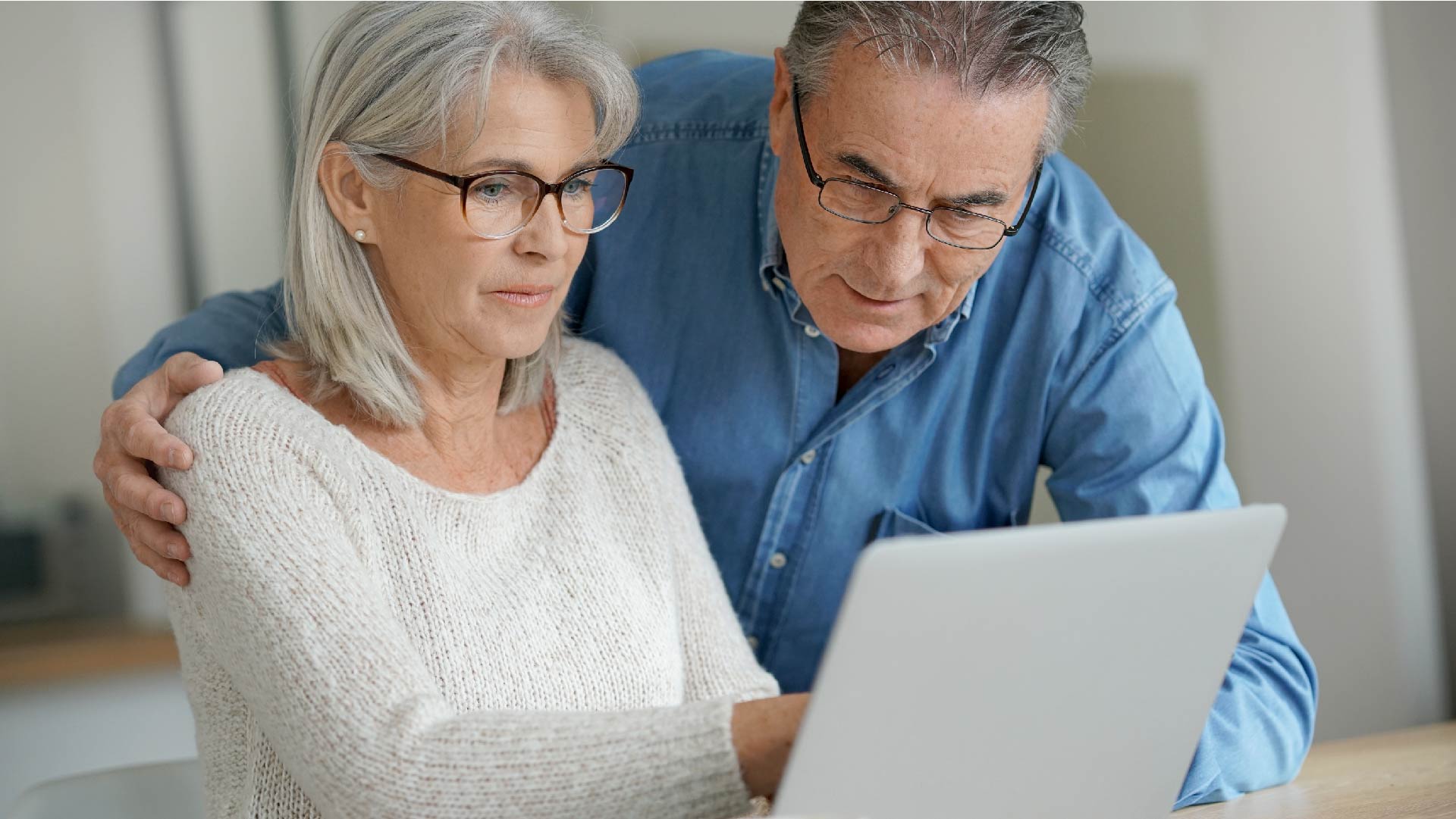 Un couple âgé utilise leur ordinateur portable à la maison