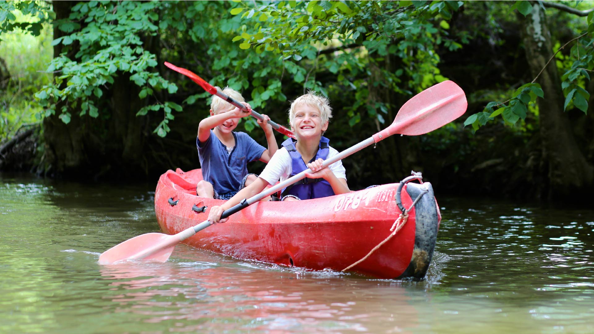 Twee jongens nemen deel aan een stage en kayakken