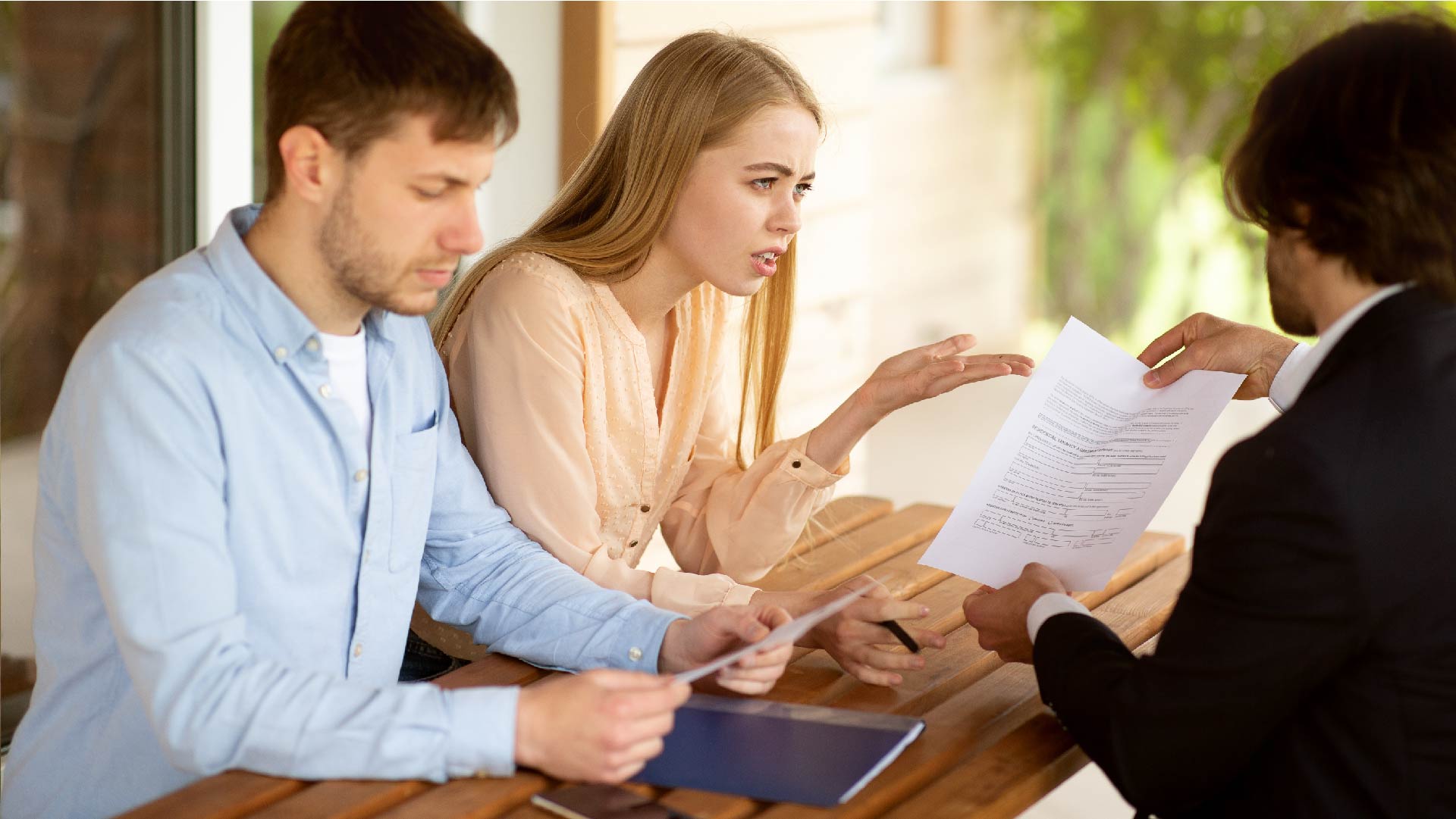 Un jeune couple n&#039;est pas d&#039;accord avec le document que montre leur courtier