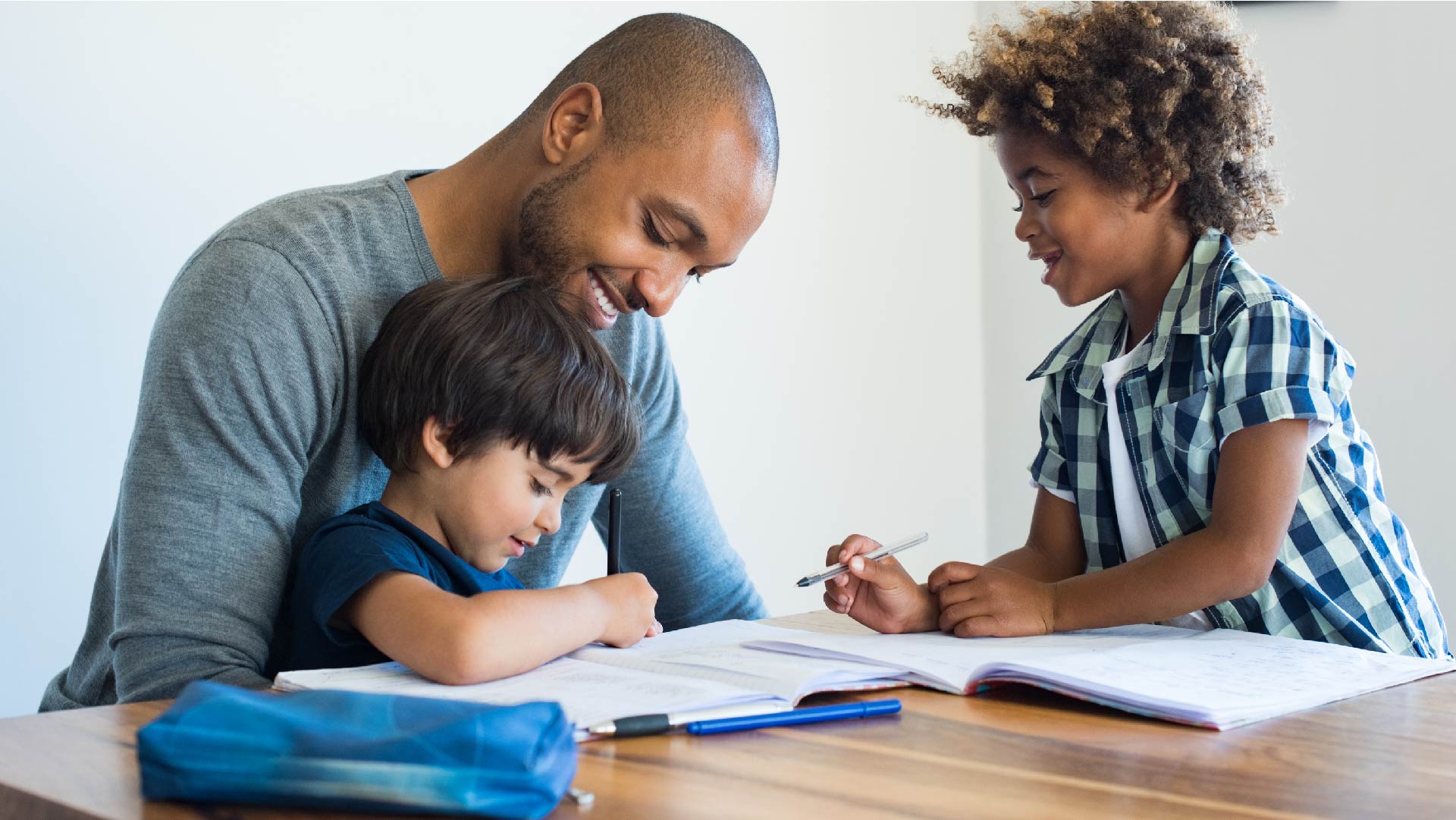 Un jeune père aide ses enfants à faire leurs devoirs