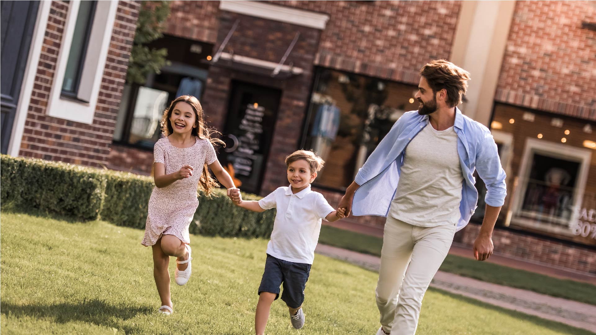 Un papa et ses enfants courent dans leur jardin