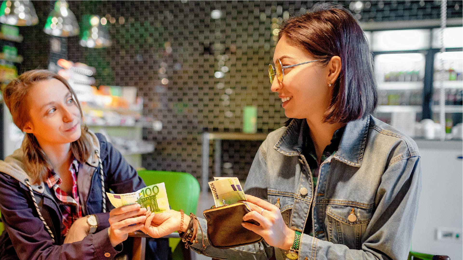 Een meisje leent geld aan haar vriendin op café