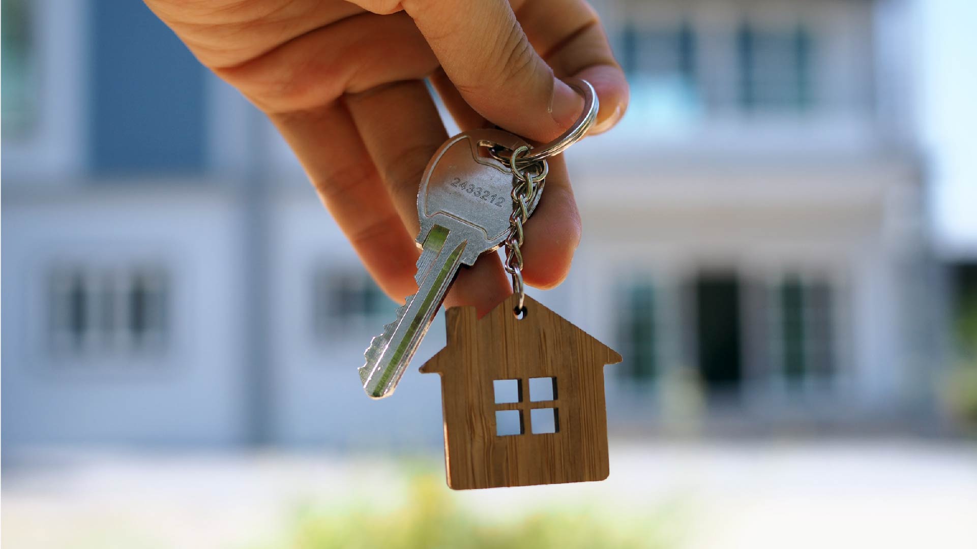 Een hand houdt een sleutel van een huurhuis vast