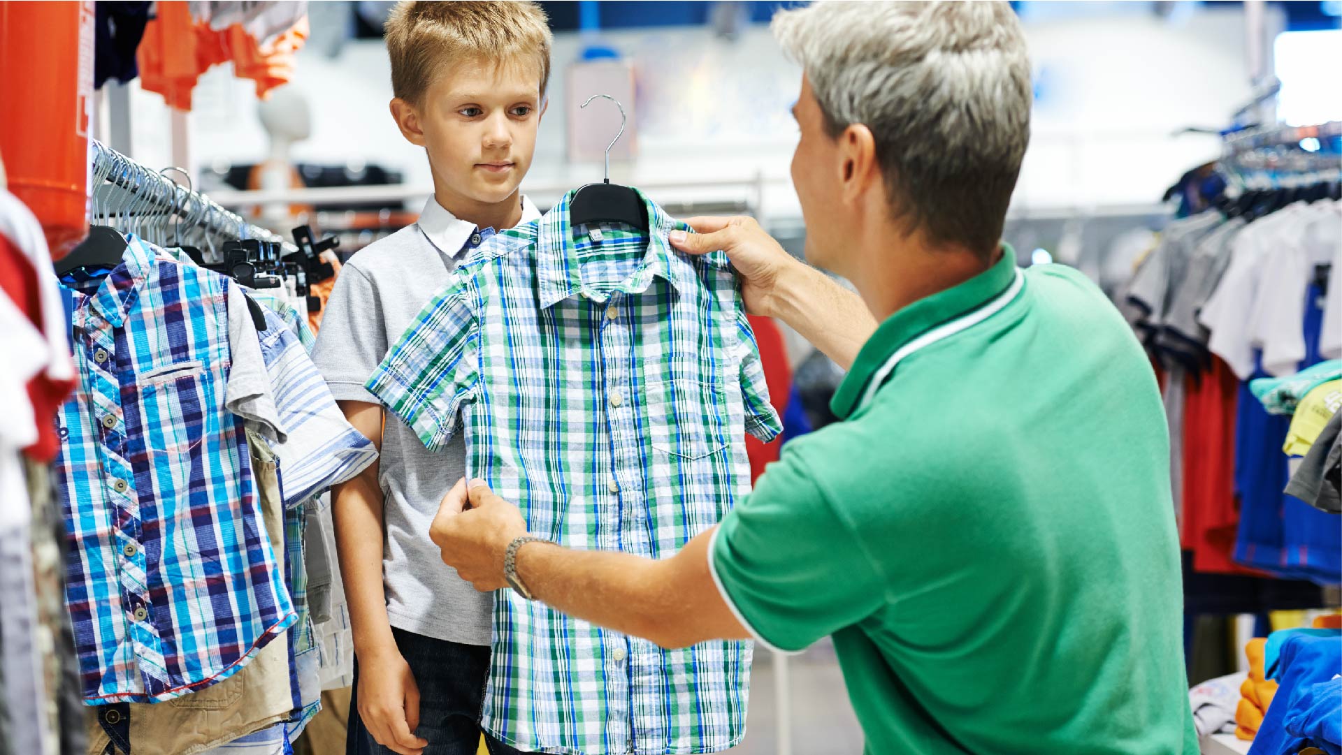 Een man koopt kleren voor zijn zoon