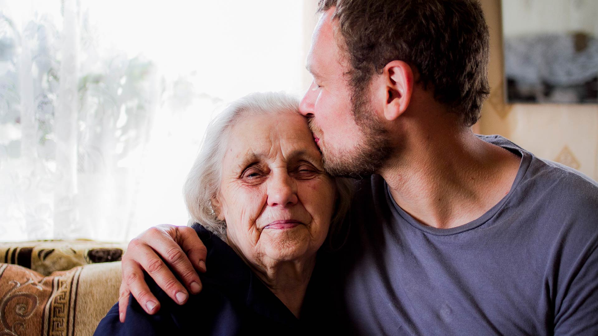 Un jeune homme embrasse sa grand-mère