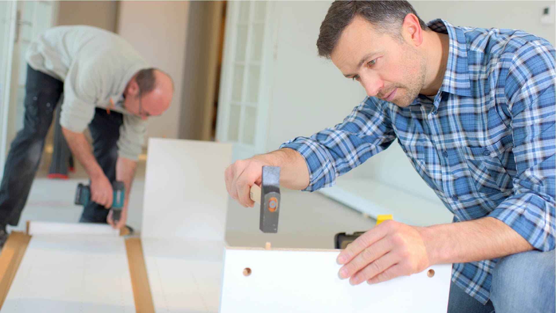 Twee werknemers steken meubels in elkaar Twee werknemers steken meubels in elkaar