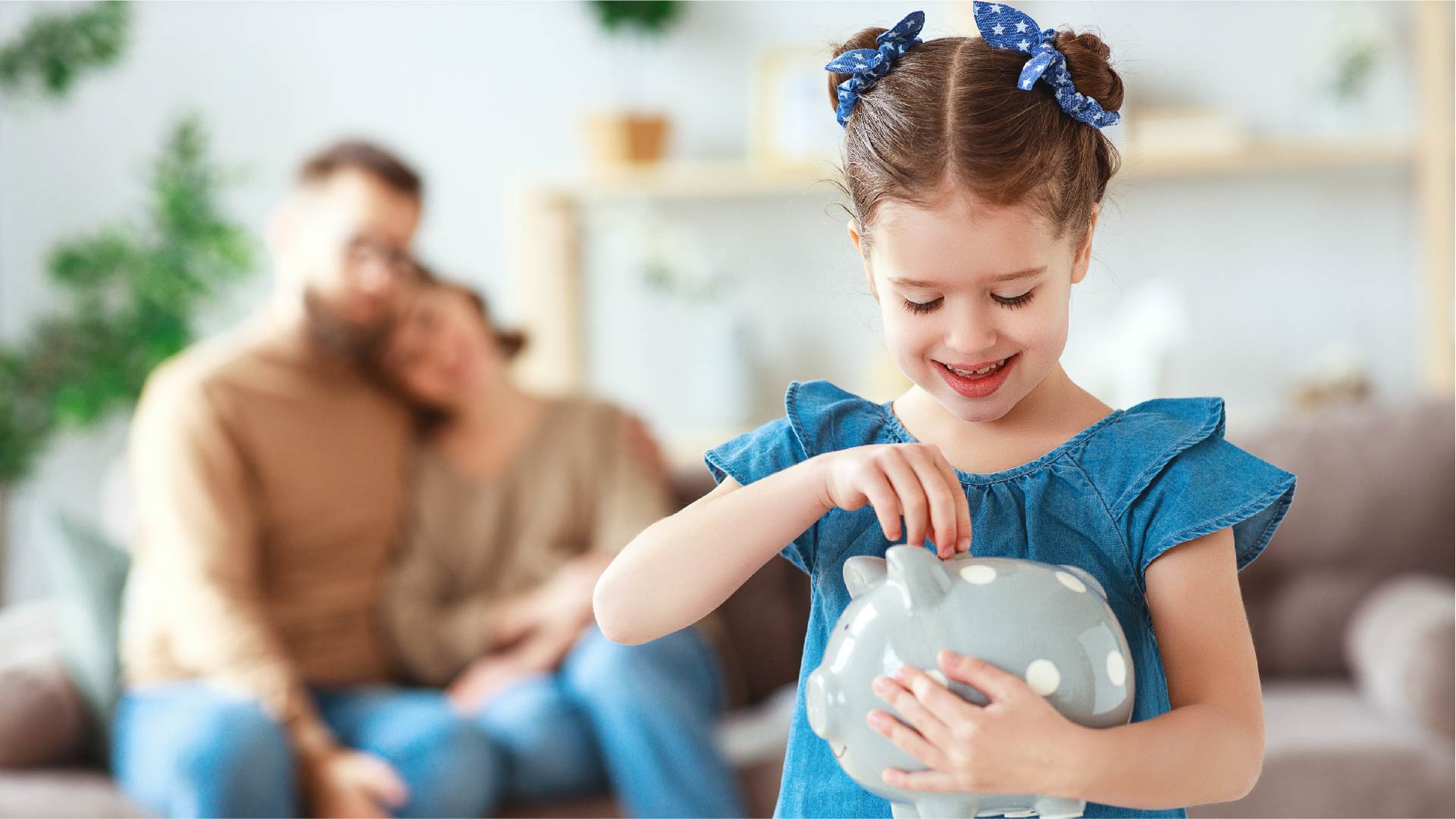 Ouders in een omhelzing bekijken hun dochtertje dat geld in een spaarpot steekt