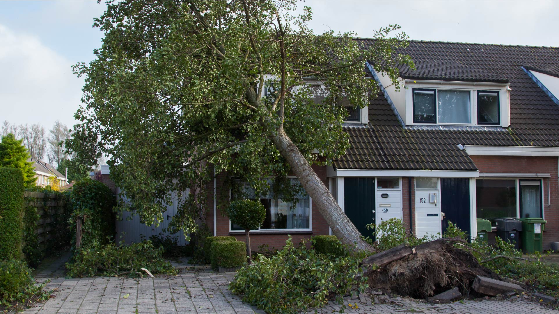 Een boom is tijdens een storm op een huis gevallen