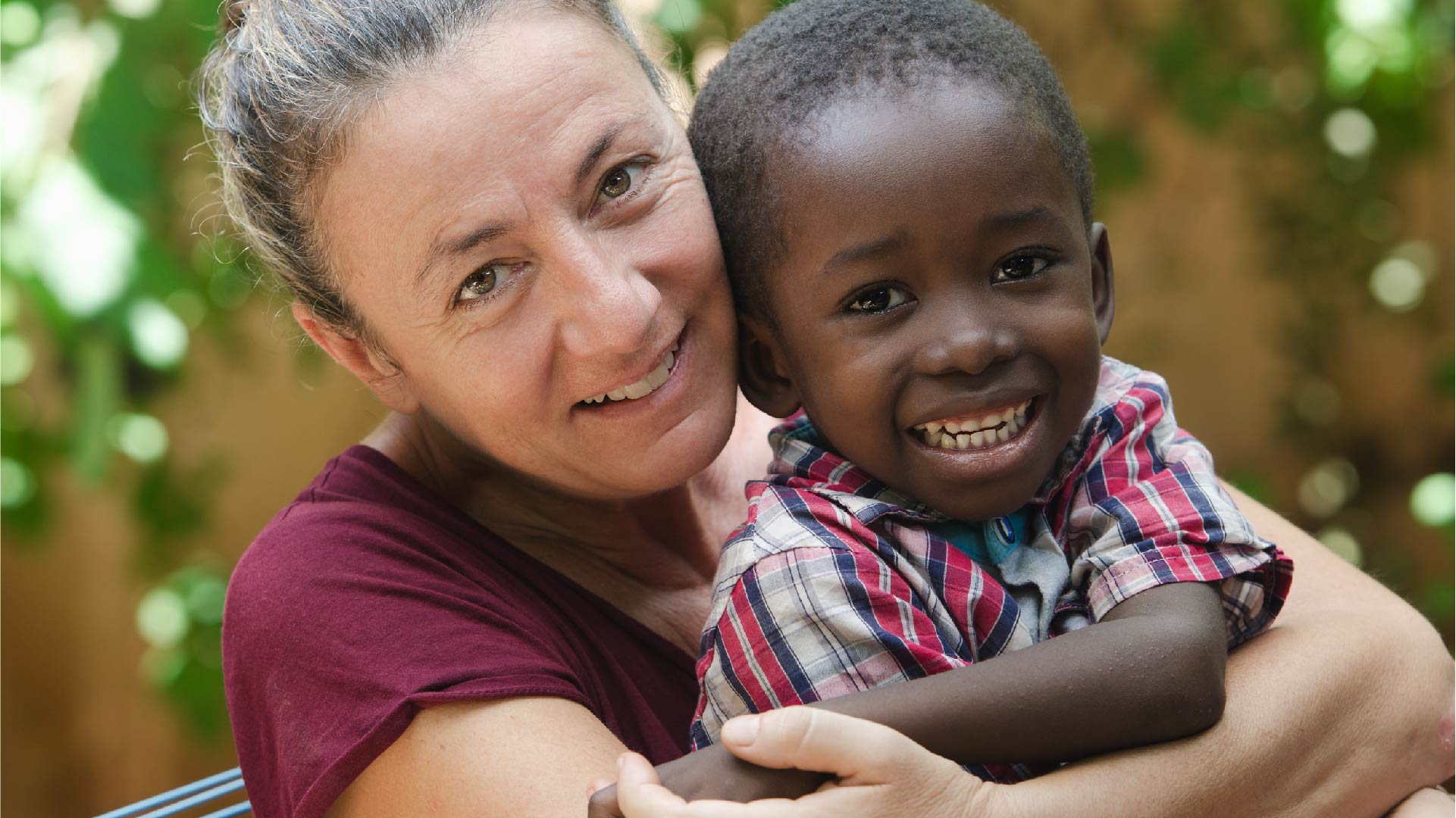 Une femme adopte un petit garçon, les deux sourient