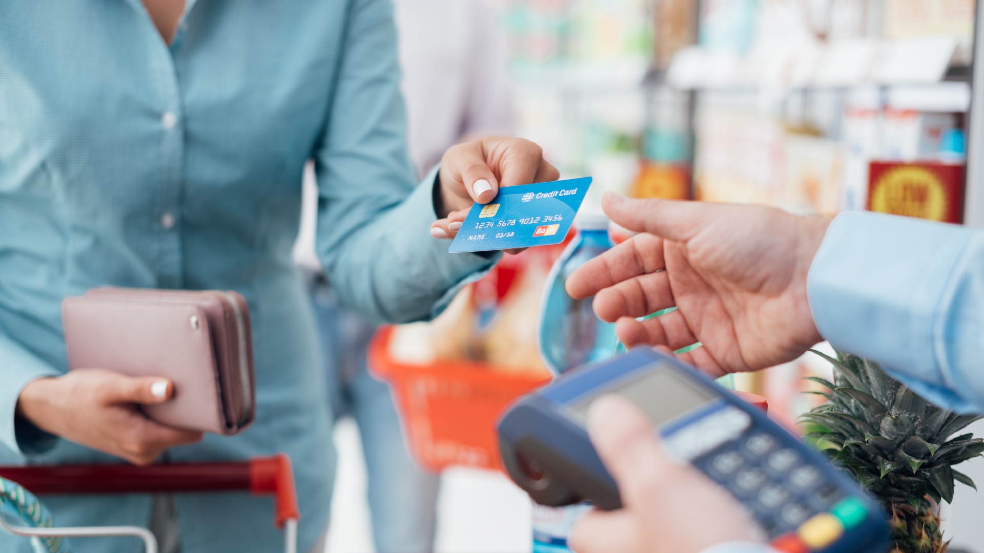 Een vrouw betaalt met kaart aan de kassa van een supermarkt