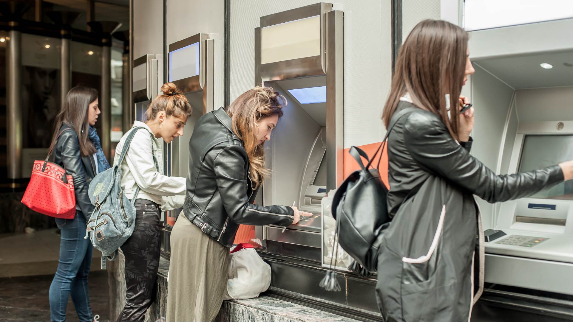 Quatre femmes retirent de l&#039;argent au distributeur automatique de billets
