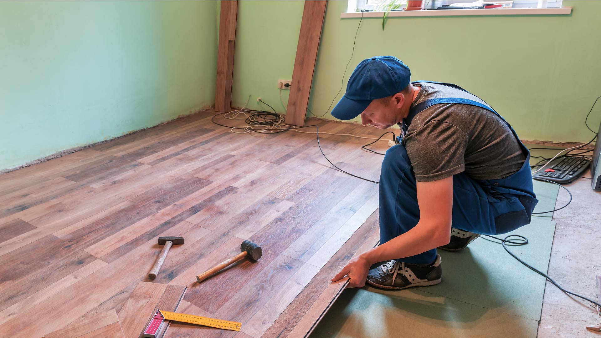 Un travailleur pose du parquet 