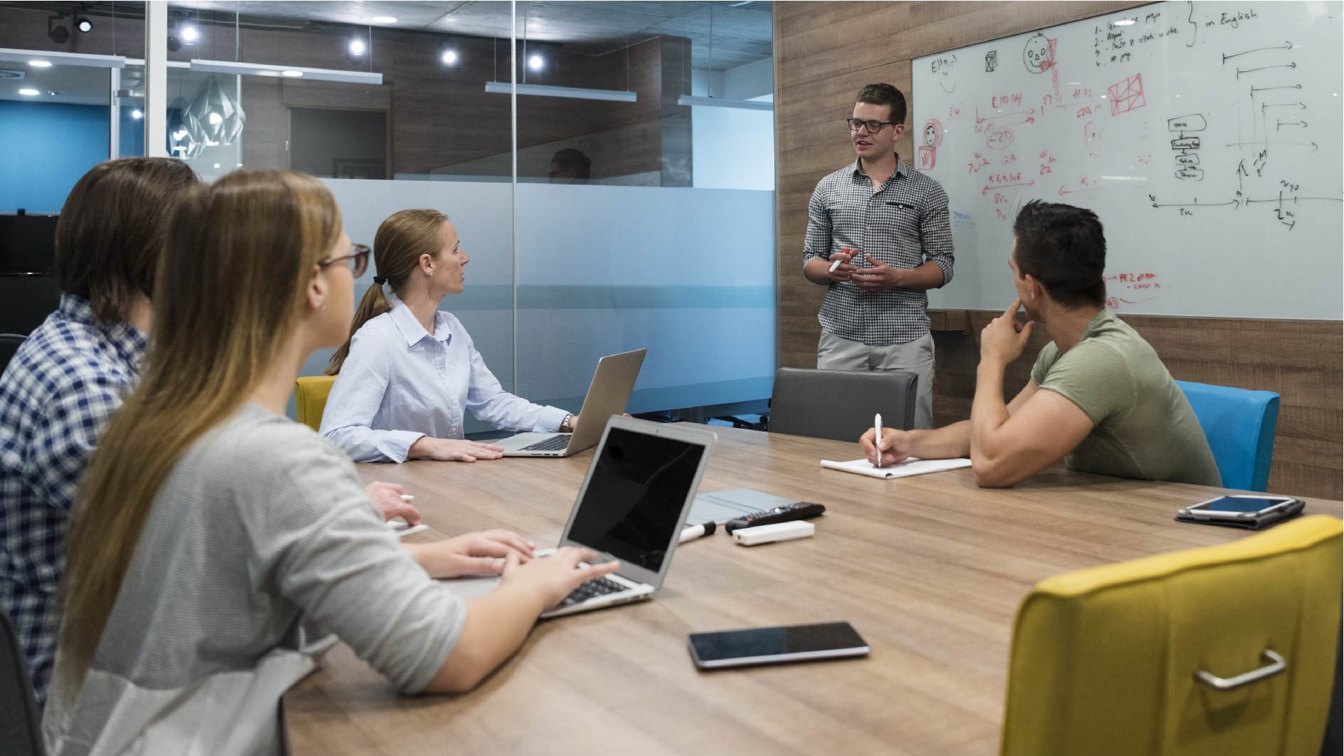 Une équipe de jeunes entrepreneurs brainstorme sur leurs tablettes et ordinateurs portables