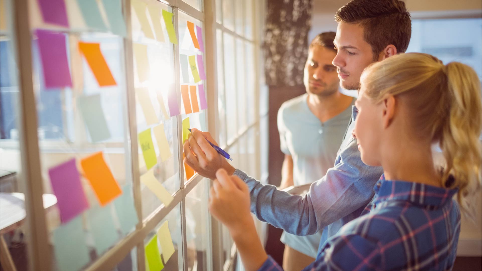 Des jeunes collent des post-it et réfléchissent ensemble