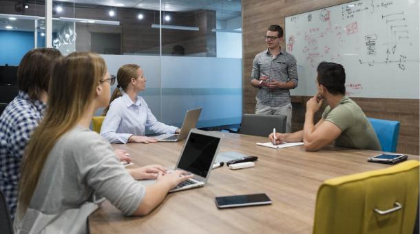 Een ploeg jonge ondernemers brainstormt op hun tablets en laptops Een ploeg jonge ondernemers brainstormt op hun tablets en laptops