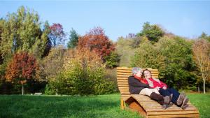 Un couple d&#039;âge mûr allongé sur un transat en bois dans un grand jardin
