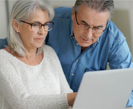 Un couple âgé utilise leur ordinateur portable à la maison