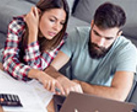Un couple fait ses tâches administratives et regarde l&#039;ordinateur