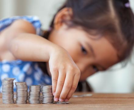 Een klein meisje maakt stapeltjes munten
