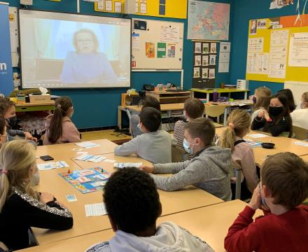 Koningin Mathilde doet een videochat met leerlingen die een budgetspel speelden in de klas