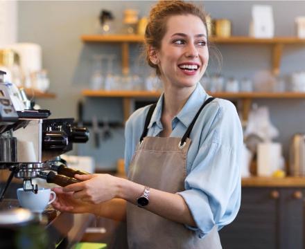 Een studente heeft werk gevonden en maakt koffie in een bar