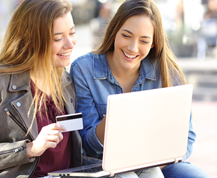 2 vrouwen kopen online op hun laptop met hun kredietkaart