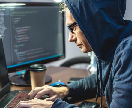 Een jonge man typt op zijn computer