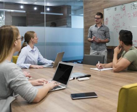 Une équipe de jeunes entrepreneurs brainstorme sur leurs tablettes et ordinateurs portables